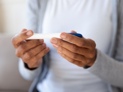 Woman holding pregnancy test.